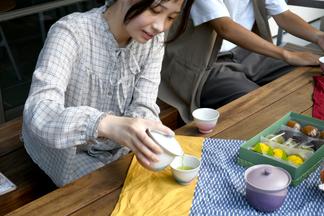 自分でデザインした急須と湯呑みでお茶を楽しむ学生