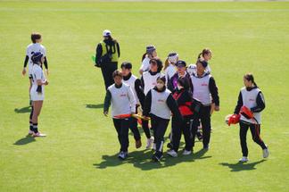 ケガをした選手を担架で運ぶ学生