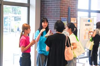来場者に声掛けをする学生スタッフ