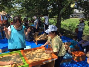 木製のホッケーでお子さんの対戦相手と審判をする学生