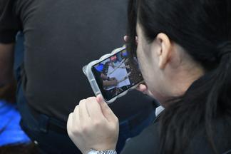祭りの準備をスマートフォンで撮影する学生