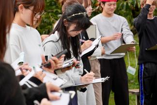 メモを取りながら、観光農園の取り組みについて学ぶ学生
