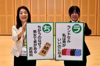 「ジェンダーかるた」展示会場で高倉房子氏（久留米市協働推進部男女平等推進センター）と森山さん