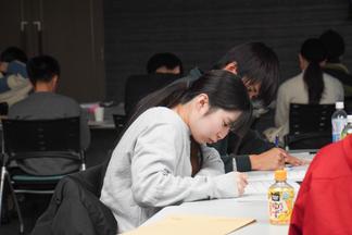 真剣にメモを取りながら講義を受ける学生