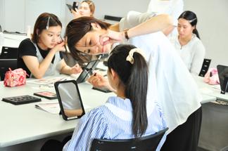 メイクのプロからアドバイスを受ける学生