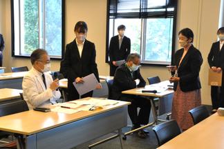 試作のシールを見ながら、惠紙病院長に意見を求める様子