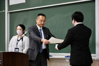 表彰状を授与する真部学部長（商学部）