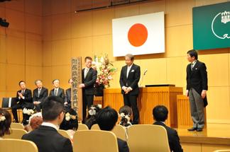 学校看板の受け渡しを終えた西学校長、内村理事長・学長、臨床検査専門学校同窓会会長