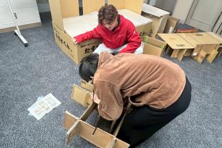 段ボールベッドを組み立てる演習を行う学生