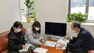 御井学舎事務部 重石部長(右)と打ち合わせをする学生