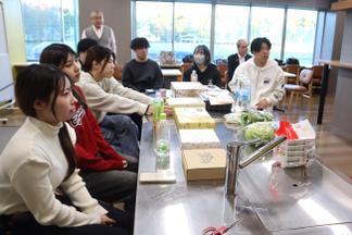 商品の撮影方法についてレクチャーを受ける学生