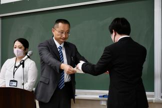 表彰状を授与する真部学部長（商学部）