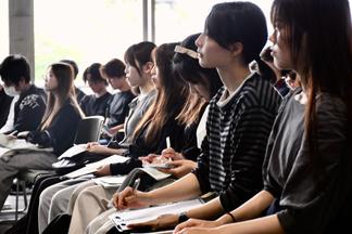 メモを取りながら説明を聞く学生たち
