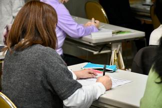 説明にうなずきながらメモを取る参加者