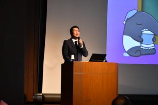 かわいらしいイラストのスライドを使って講演する精神神経科診療科の坂本賢治作業療法士