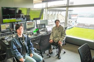 会場が見渡せる操作室から大型モニターへの映像発信をサポートした情報社会学科の学生