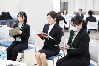 メモを取りながら真剣に話を聞く学生