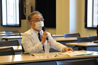 プレゼンテーションにコメントをする惠紙医療センター病院長