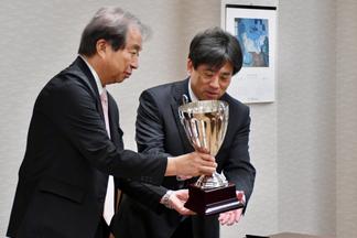 ナナイロプリズム福岡が「Tradition HKFC Tens 2026」で獲得した優勝カップを手にする内村理事長兼学長ら