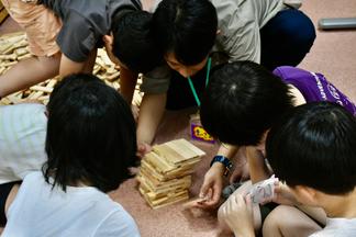 子どもたちと教具を使って遊ぶ学生