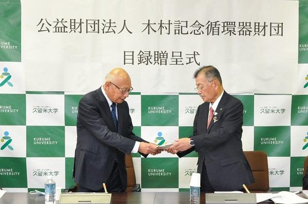 古賀木村財団理事長(左)から目録を受け取る永田理事長(右)