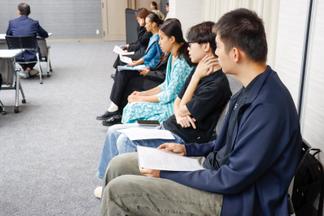 緊張しながら他の人のスピーチを聞く参加者たち