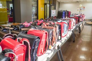 会場で子どもたちを待つランドセル（一つ一つ学生手作りのお守りを付けました）