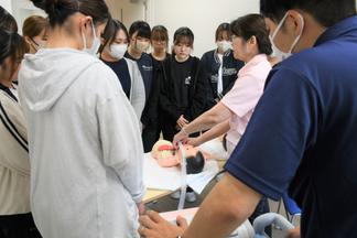 医ケア児人形に呼吸器を装着する様子