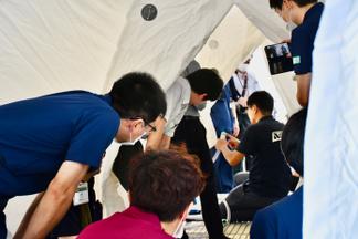 テント内の設備について説明を受ける参加者
