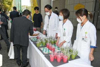 グラウンドの完成式典でスムージーを提供する医療センター栄養室のスタッフ