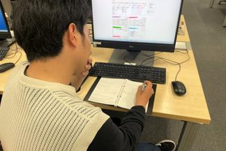 アイデアマラソンノートにメモを取りながら講師の話を聞く様子