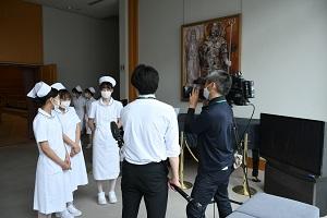 写真右:メディアの取材に答える学生