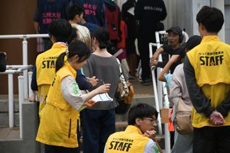 ステージ袖で競技の進行を管理する学生たち