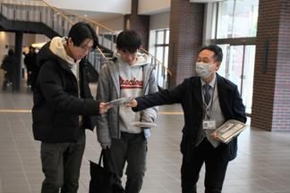 チラシとエコバッグを配る職員